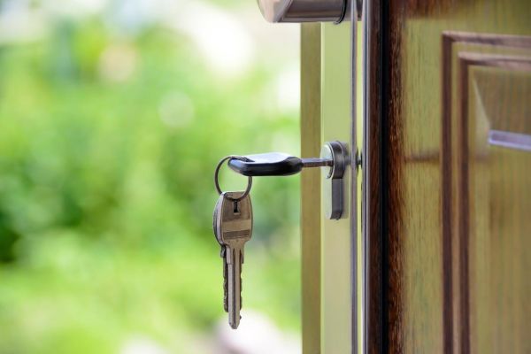 A ley hanging from the lock of the front door of a house
