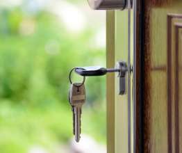 A ley hanging from the lock of the front door of a house