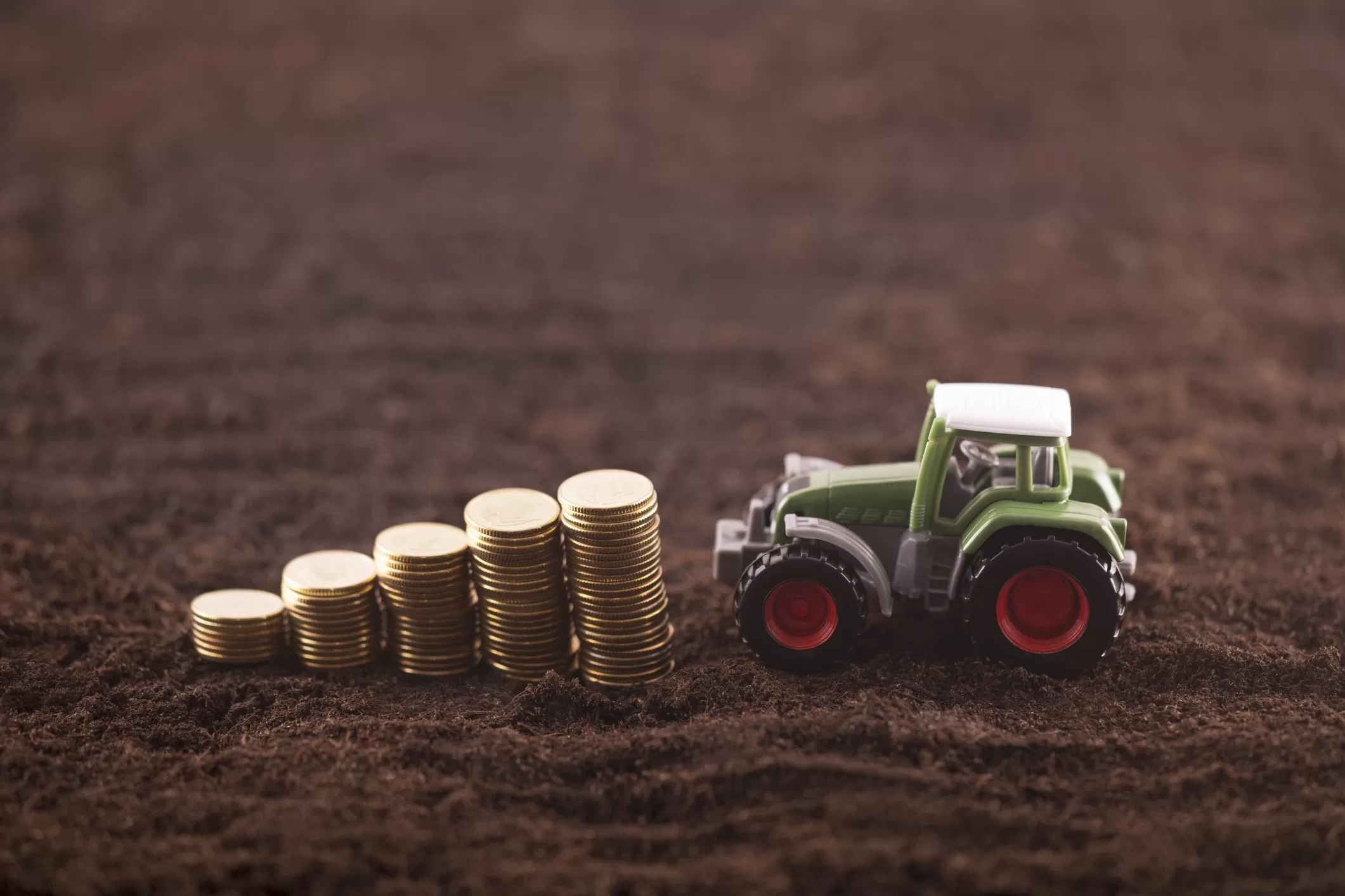 Toy tractor pushing coins